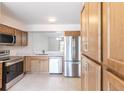 Bright kitchen with stainless steel appliances, quartz countertops, and light wood cabinets at 16175 Rambling Vine E Dr, Tampa, FL 33624