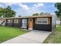 Well-maintained single story home with a lush green lawn, inviting front door, and freshly sealed driveway at 1707 Windsor Way, Tampa, FL 33619