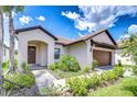 Inviting single-story home featuring a tile roof, manicured landscaping, and an attached two-car garage at 17140 Holly Well Ave, Wimauma, FL 33598