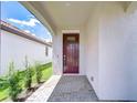 Covered front porch with brick flooring and a dark wood front door, offering curb appeal at 17140 Holly Well Ave, Wimauma, FL 33598