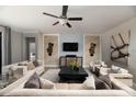 Spacious living room with modern decor, a ceiling fan, and comfortable seating arrangement at 17140 Holly Well Ave, Wimauma, FL 33598