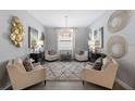Cozy living room featuring neutral colors, art, rug, comfortable seating, and an elegant chandelier at 17140 Holly Well Ave, Wimauma, FL 33598