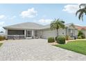 Charming single-story home with a well-maintained paver driveway, mature landscaping, and welcoming entrance at 2306 Emerald Lake Dr, Sun City Center, FL 33573