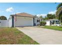 Exterior view of home showing driveway, garage, fence, and lawn with flower bed at 2650 60Th N Ave, St Petersburg, FL 33714