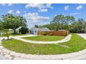 Well-manicured lawn and landscaping accentuates this home's curb appeal, complemented by a curved driveway at 2692 Cedarbrooke Dr, Palm Harbor, FL 34684