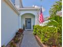 Charming entryway with an American flag, a wreath and well-manicured landscaping at 314 Blackrock Ln, Apollo Beach, FL 33572