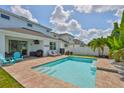 Inviting backyard pool area with brick pavers, lounge chairs, and a beautiful view of neighboring houses at 314 Blackrock Ln, Apollo Beach, FL 33572
