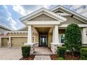 View of the front entrance with a decorative door, stone accents, and well-manicured greenery at 4222 Glade Wood Loop, New Port Richey, FL 34655
