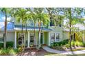 Charming two-story home with lush landscaping, front porch swing, and inviting curb appeal at 5518 Luminar Pointe Ln, Apollo Beach, FL 33572