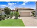 Charming home with a brick driveway, a two-car garage, and meticulously maintained landscaping at 8605 Grand Alberato Rd, Tampa, FL 33647
