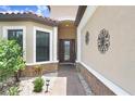 Inviting front entry featuring a decorative glass door, stone accents, and manicured landscaping at 8605 Grand Alberato Rd, Tampa, FL 33647