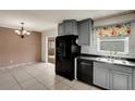 Eat-in kitchen featuring stylish gray cabinets, black appliances, and tile flooring at 915 S Miller Rd, Valrico, FL 33594