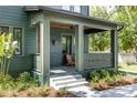 Inviting front porch of home with wood ceiling, Adirondack chair, and well maintained yard at 101 E Lambright St, Tampa, FL 33604