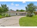 Inviting single-story home featuring a driveway and well-maintained lawn with mature trees at 10237 Carrin Rd, Spring Hill, FL 34608