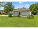 The side yard is well maintained with plush green grass and lush landscaping at 10237 Carrin Rd, Spring Hill, FL 34608
