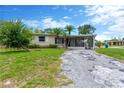 Charming single-story home featuring a large front yard, palm trees and a screened in porch at 11896 104Th Ln, Largo, FL 33773