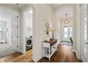 Inviting entryway featuring hardwood floors and leading to the laundry room and the rest of the house at 12643 Shetland Walk Dr, Lithia, FL 33547