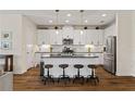 Bright kitchen boasts white cabinets, granite counters, modern appliances, and a central island with seating at 12643 Shetland Walk Dr, Lithia, FL 33547