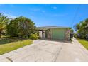 Cozy single-story home featuring a stone-accented garage door, lush landscaping, and a spacious driveway at 12829 3Rd Isle, Hudson, FL 34667