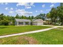 Cozy single-Gathering home showcases a wide lawn, a paved driveway, and an attached two-car garage at 15108 Winterwind Dr, Tampa, FL 33624