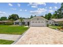 Lovely single-story house featuring a lush green lawn, a paved driveway, and an attached two-car garage at 15108 Winterwind Dr, Tampa, FL 33624