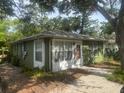 Exterior shot of a one-story home with mature trees, a driveway, and a view of the front door at 159 6Th Nw St, Largo, FL 33770