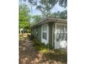 Side exterior view of the house with green paint and white trim at 159 6Th Nw St, Largo, FL 33770