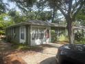 Exterior shot of a one-story home with mature trees, a driveway, and a view of the front door at 159 6Th Nw St, Largo, FL 33770