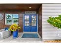 Inviting front entrance with decorative blue door, lush landscaping, and charming exterior details at 16106 6Th E St, Redington Beach, FL 33708