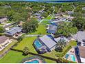 Aerial view of a home with a screened-in pool and lush landscaping in a quiet, tree-lined neighborhood at 1910 Montego Ct, Oldsmar, FL 34677