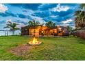 Spacious backyard with a fire pit and a screened-in porch, perfect for outdoor entertaining and relaxation at 1910 Montego Ct, Oldsmar, FL 34677
