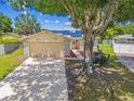 Charming single-story home featuring a large tree, a two-car garage, and a well-manicured lawn at 1910 Montego Ct, Oldsmar, FL 34677