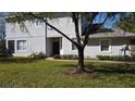 Quaint townhome featuring lush green lawn and colorful floral arrangements leading to a classic dark blue front door at 19232 Stone Hedge Dr, Tampa, FL 33647