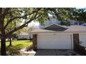 Attached two-car garage features a clean, white door and stone accents enhancing the home's curb appeal at 19232 Stone Hedge Dr, Tampa, FL 33647