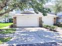 Double garage with stone accents, providing ample parking and curb appeal at 19232 Stone Hedge Dr, Tampa, FL 33647