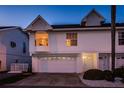 Inviting nighttime view of a two-story townhome with a one-car garage and warm lighting, showcasing its curb appeal at 19717 Gulf Blvd # V5, Indian Shores, FL 33785