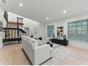Spacious living room showcases hardwood floors, a staircase, and a comfortable sofa, perfect for modern living at 2272 Adam Ct, Palm Harbor, FL 34683