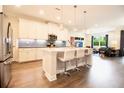 Modern eat-in kitchen with island seating, sleek appliances, and hardwood floors at 2435 Foggy Creek Cir, Clearwater, FL 33764