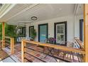 Inviting front porch featuring tile flooring, a cozy porch swing, and charming decor, perfect for relaxing at 2820 Whitney Rd, Clearwater, FL 33760