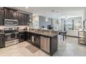 Modern kitchen featuring stainless steel appliances, granite countertops, and open layout connecting to the living room at 28504 Tranquil Lake Cir, Wesley Chapel, FL 33543