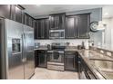 Modern kitchen featuring stainless steel appliances, granite countertops, and dark wood cabinetry at 28504 Tranquil Lake Cir, Wesley Chapel, FL 33543
