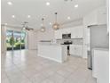 Open-concept kitchen featuring a kitchen island, stainless steel appliances, and abundant natural light at 2885 Deer Pine Trl, Land O Lakes, FL 34638
