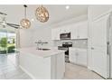 Well-lit kitchen showcasing the kitchen island, stainless steel appliances, and open layout at 2885 Deer Pine Trl, Land O Lakes, FL 34638