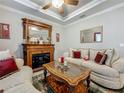 Cozy living room with a decorative fireplace, neutral furnishings, and a ceiling fan for added comfort at 33668 Willow Point Ct, Wesley Chapel, FL 33545