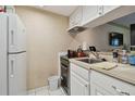 Compact kitchen features white appliances, cabinetry, and tile flooring at 36750 Us 19 N # 09208, Palm Harbor, FL 34684