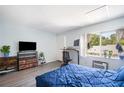 A well-lit bedroom with ample sunlight, a large window, wooden flooring, and an entertainment center at 4130 Dolphin Dr, Tampa, FL 33617