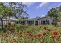 Landscaped front yard with flowering plants and ranch style home at 4206 W Palmira Ave, Tampa, FL 33629