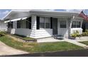 Cozy home with white siding, manicured lawn, and an American flag at 4851 W Gandy Blvd # B2L10, Tampa, FL 33611