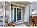 Close-up of the inviting front door, enhanced by colorful foliage and attractive siding at 500 New York Ave # 22, Dunedin, FL 34698