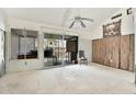 Spacious living room ready for renovation, featuring a ceiling fan, sliding glass doors and insulation at 500 New York Ave # 22, Dunedin, FL 34698